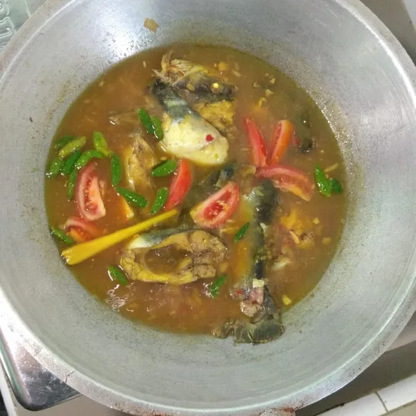 Masukkan irisan tomat, cabai rawit, dan nanas. Masak hingga cabai mulai layu, dan ikan matang