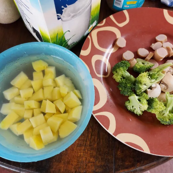Kupas kentang, potong dadu. Potong-potong jamur, sosis, brokoli .