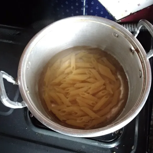 Didihkan air kemudian rebus pasta panne, garam, dan minyak sayur. Masak selama 15 menit.