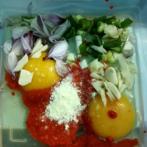 Siapkan wadah lalu masukan telur, irisan bawang merah, bawang putih, daun bawang dan kaldu bubuk. Aduk rata.