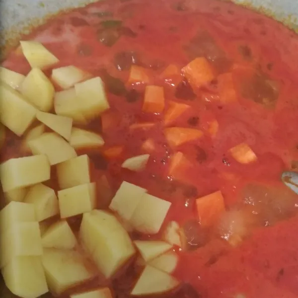 masukkan kentang, wortel, dan ayam ke dalam kuah tomat, masak hingga airnya mengering.