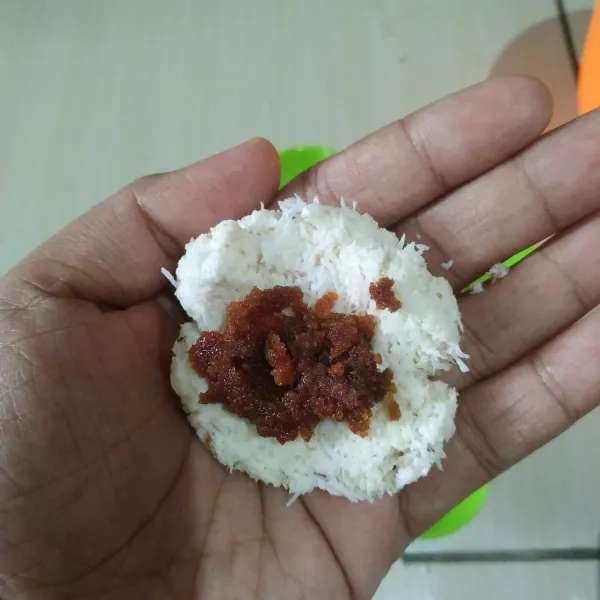Ambil sedikit adonan, kemudian pipihkan. Isi dengan gula merah sisir. Bulatkan lalu pipihkan.
