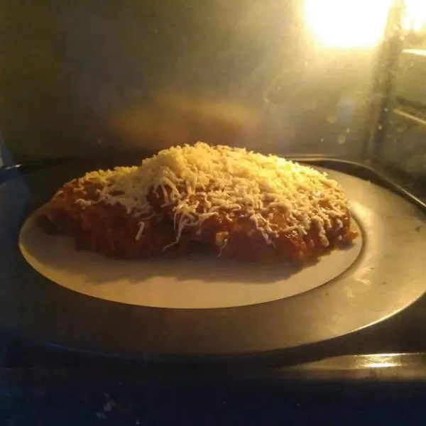 Panaskan oven, masukkan ayam Parmigiana me dalam oven, panggang sampai keju mozzarella meleleh, angkat dan sajikan bersama kentang goreng, buncis dan wortel rebus.