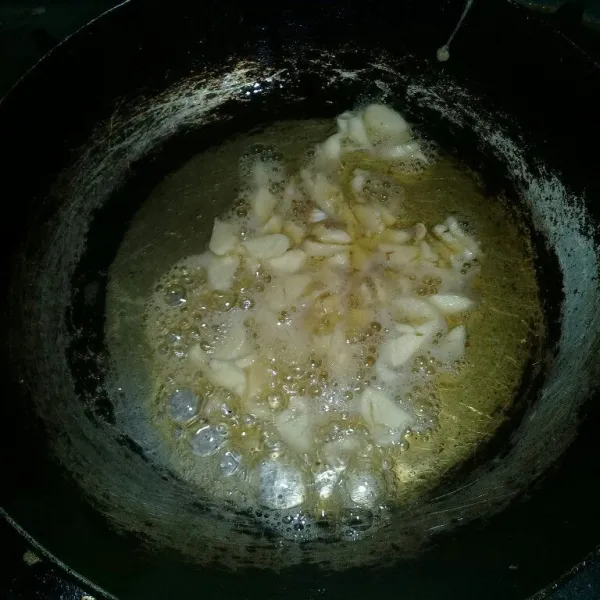 Panaskan minyak dalam wajan. Tumis bawang putih hingga golden brown. Angkat dan pindahkan ke piring. Sisakan minyaknya yang ada di wajan.