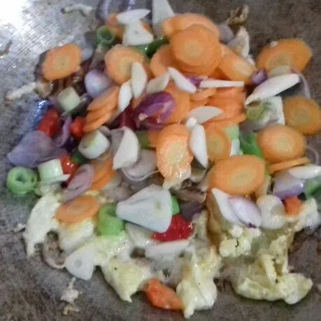 Masukkan bawang merah, bawang putih dan cabai. Tumis hingga wangi. Lalu masukkan wortel dan daun bawang.