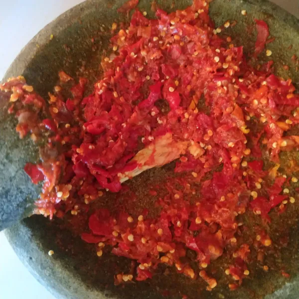 Haluskan bawang merah, bawang putih, cabe merah keriting dan cabe rawit.