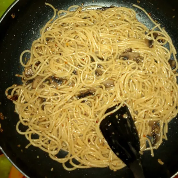 Masukkan spaghetti dan sedikit air rebusan. Masak sampai air habis.