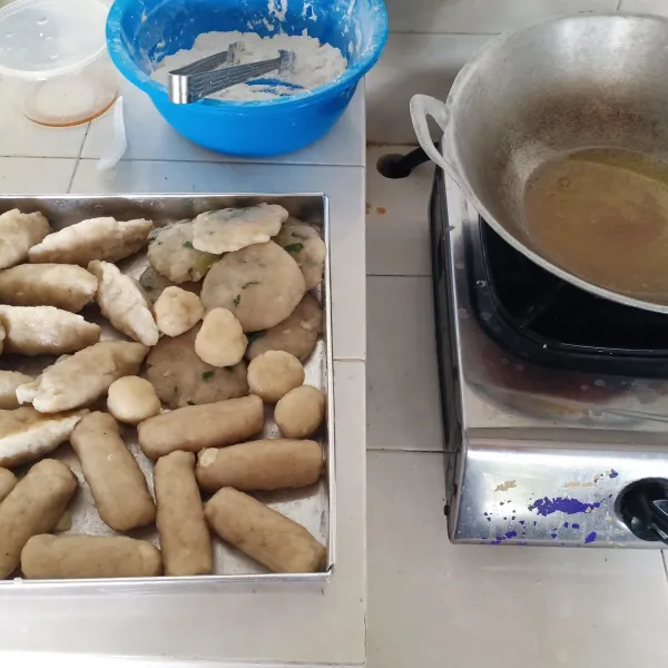 Setelah matang, pempek ditiriskan dan goreng dengan minyak panas.