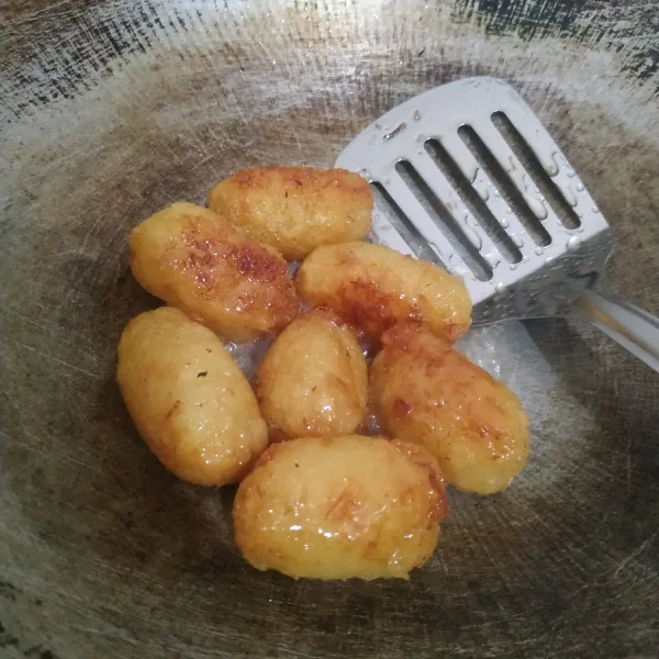 Kecilkan api, masukkan ubi singkong goreng. Aduk terus sampai gula mengering. Angkat.