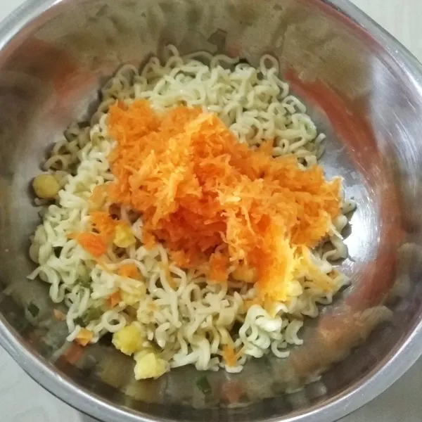 Masukkan telur kocok dan wortel ke dalam mie instan yang sudah direbus. Aduk hingga tercampur rata.