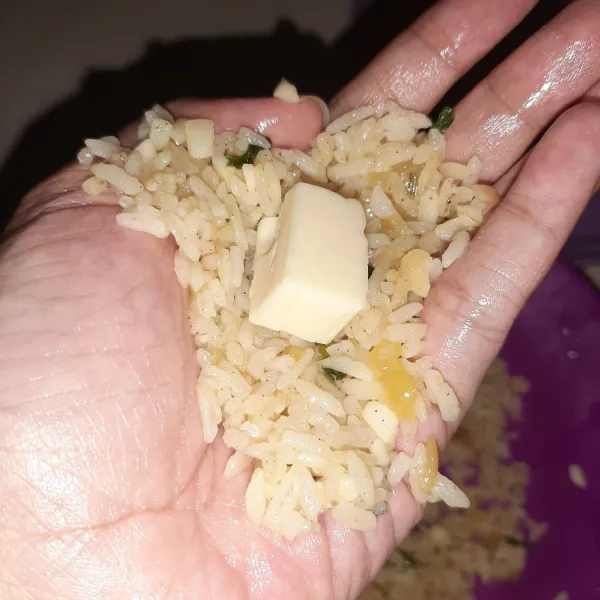 kalau nasi sudah dingin, letakkan keju di tengah nasi lalu kepalkan menjadi bulat. harus agak ditekan ya biar nasi tidak ambyar.