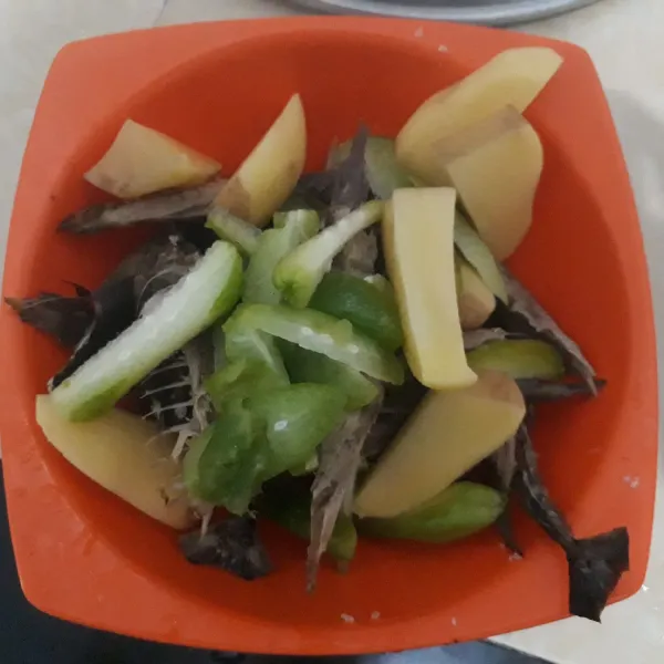 Suir ikan dan potong kecil kentang, belimbing wuluh, dan juga cabai hijau