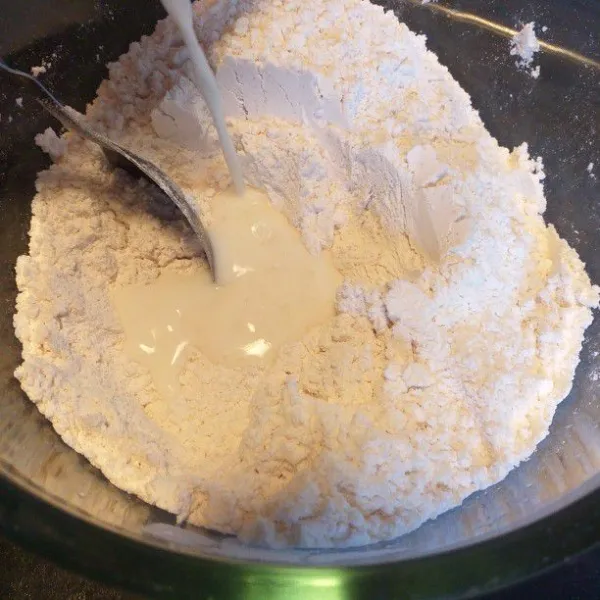 Campurkan tepung terigu, gula pasir, ragi, dan susu hangat. Aduk hingga semua bahan tercampur rata.