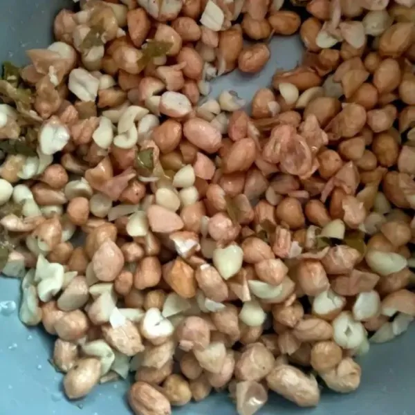 Potong kacang menjadi 2 bagian agar saat digoreng cepat garing.