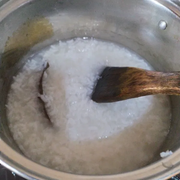 Blender nasi dengan 400 ml air, lalu tuang ke dalam panci, tambahkan salam, masak sambil terus diaduk.