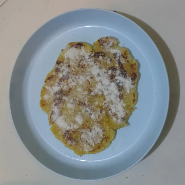 Taburkan gula putih selagi masih panas.