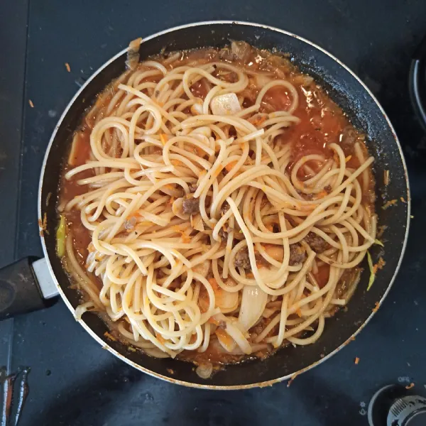 Tambahkan spaghetti, aduk-aduk hingga tercampur rata. Matikan kompor, sisihkan