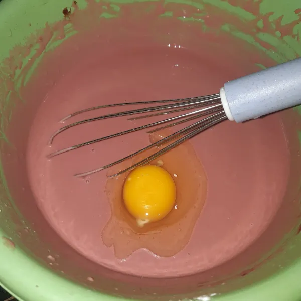Tambahkan telur. Aduk adonan menggunakan whisk hingga merata.