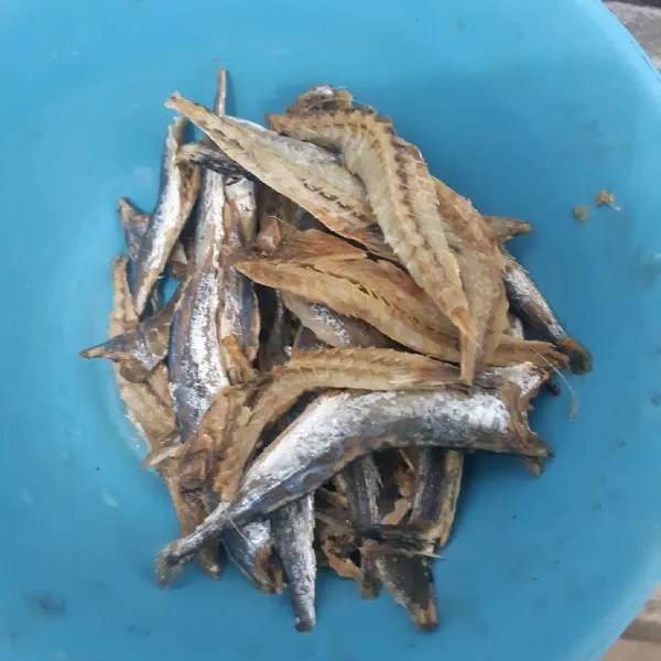 Potong ikan asin menjadi dua bagian, cuci hingga bersih menggunakan air hangat