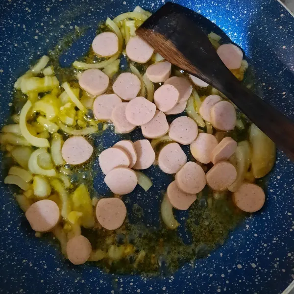 Panaskan margarine, masukkan bawang bombay dan bawang putih hingga layu dan harum. Masukkan sosis, tumis kembali hingga berubah warna.
