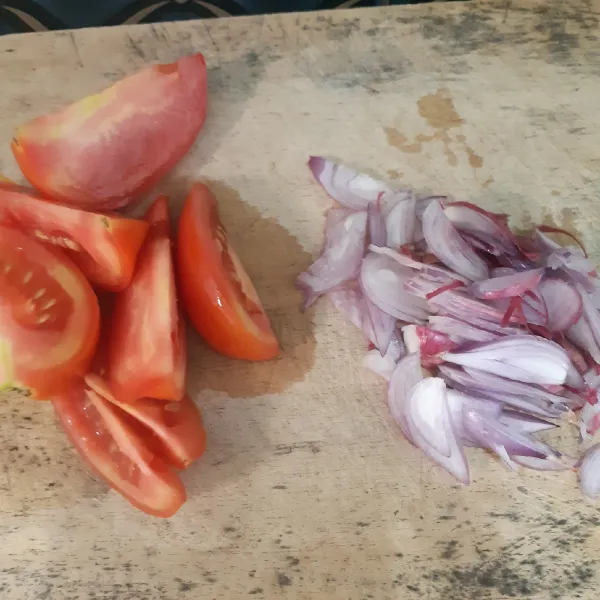 Kupas dan iris tipis bawang merah, cuci tomat kemudian potong-potong