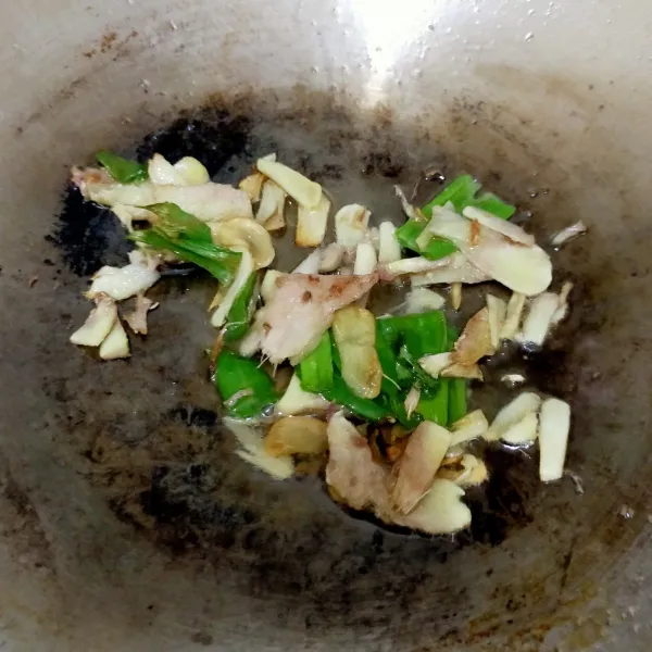 Panaskan minyak, tumis bawang putih, lengkuas, dan daun bawang yang sudah diiris hingga harum.