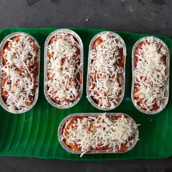 Tambahkan saus bolognese dan taburi dengan keju, lalu panggang dengan suhu 180°C hingga matang. Angkat dan sajikan.