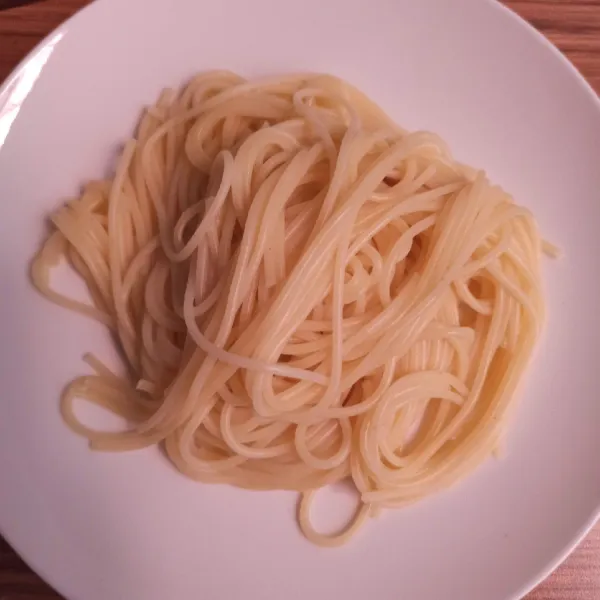 Sajikan spaghetti dalam piring, kemudian siram dengan saos bolognese.