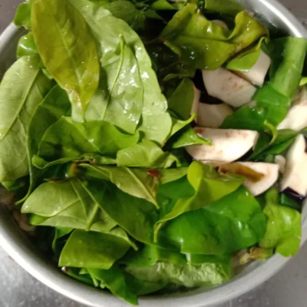 Masukkan daun melinjo dan terong. Masak sebentar.