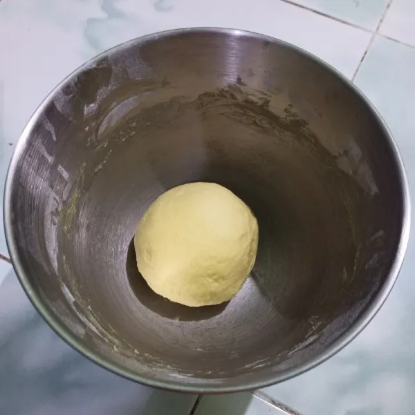 Bulatkan adonan lalu letakkan di wadah, tutup dengan plastik wrap. Diamkan 45 menit hingga mengembang 2x lipat.