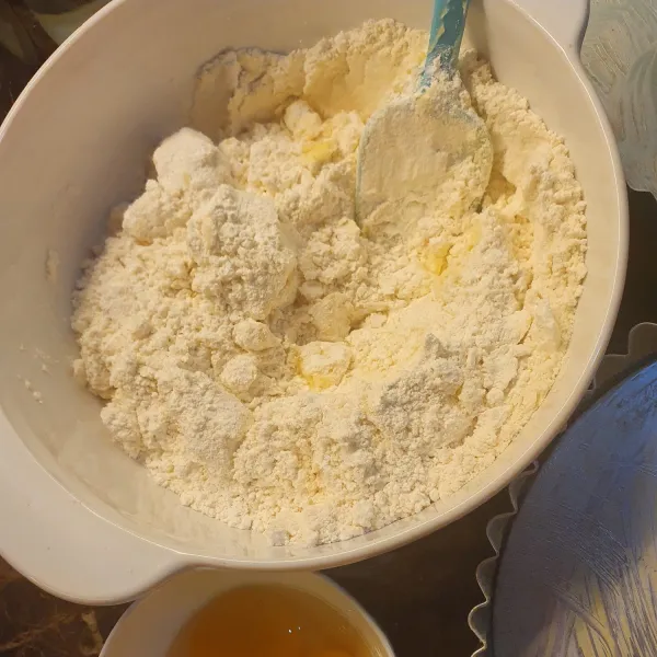 Campur tepung dan butter, aduk sampai berbutir. Masukkan kuning telur dan air es. Bulatkan, simpan dalam kulkas selama kurang lebih 40 menit.