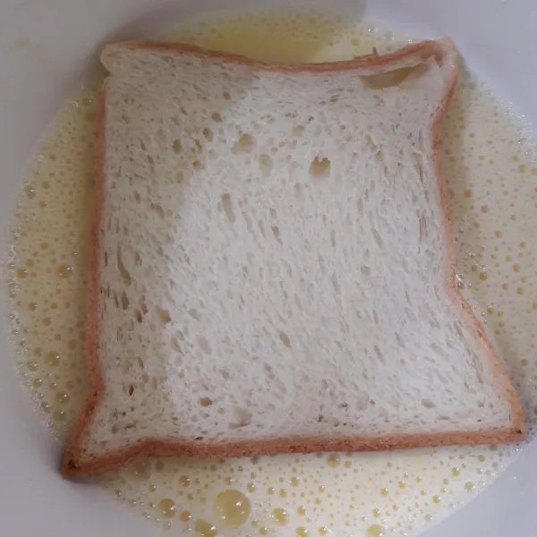 Balurkan roti ke dalam adonan.