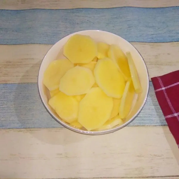 Kupas kentang dan potong dengan ketebalan 0,5 cm, sisihkan.