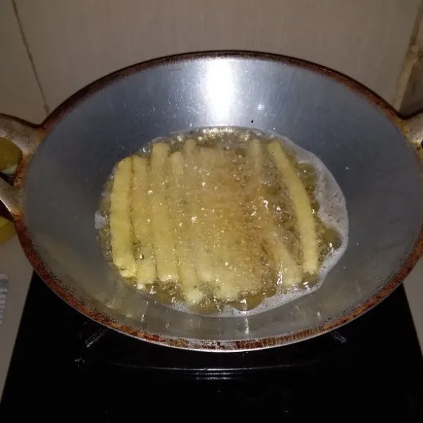 Panaskan minyak goreng. Masukkan potongan kentang. Goreng hingga kering. Setelah berwarna kecoklatan. Angkat dan tiriskan.