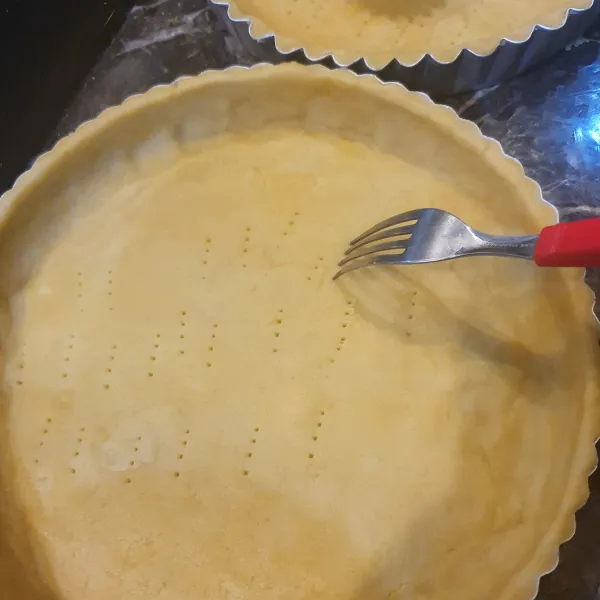 Gilas lalu cetak dalam cetakan pie yang sudah dioles dengan mentega. Tusuk dasar cetakan  dengan garpu supaya tidak menggembung. Sisihkan.