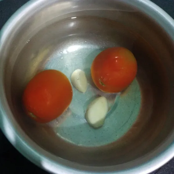 Rebus tomat dan bawang putih selama 10 menit. Blender tomat dan bawang putih dengan 100 ml air. Lalu saring airnya.