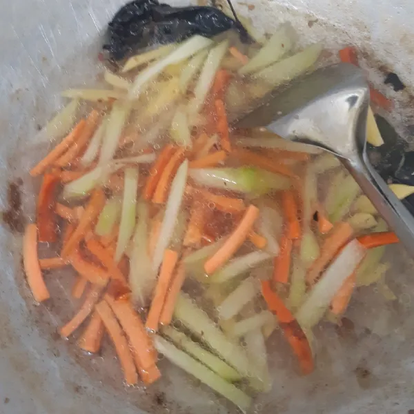 Tambahkan air. Masukkan wortel, labu siam dan kentang. Tutup panci dan masak hingga sayuran empuk.