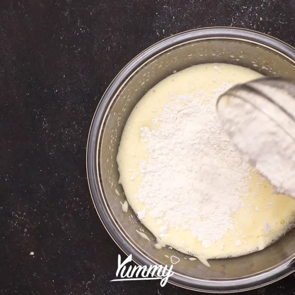 Tambahkan tepung terigu ke dalam adonan secara perlahan hingga habis lalu aduk perlahan.