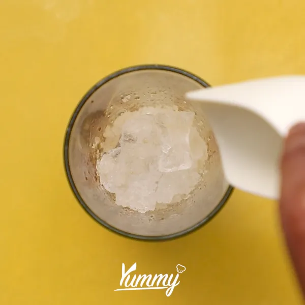 Tambahkan es batu dan tuangkan milk tea ke dalam gelas saji yang telah terisi bubble hingga penuh.