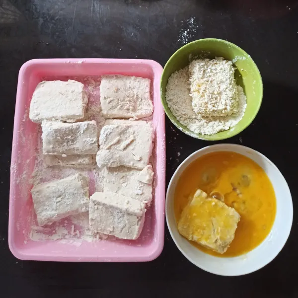 Kemudian balurkan tahu pada tepung terigu. Celupkan tahu pada telur . Kemudian gulingkan pada tepung roti. Masukkan dalam freezer selama 30-60menit.