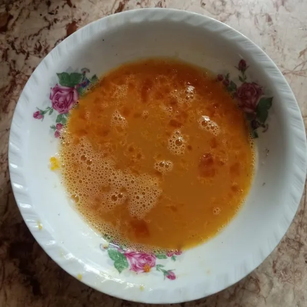 Kocok lepas telur ayam, beri bumbu.