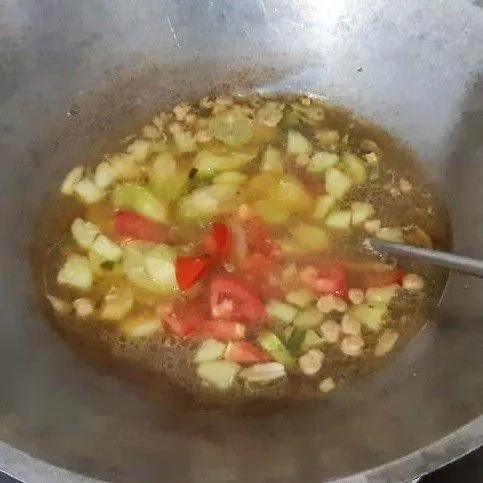 Masukkan belimbing wuluh, tomat dan cabai rawit. Masak hingga belimbing wuluh ½ matang.