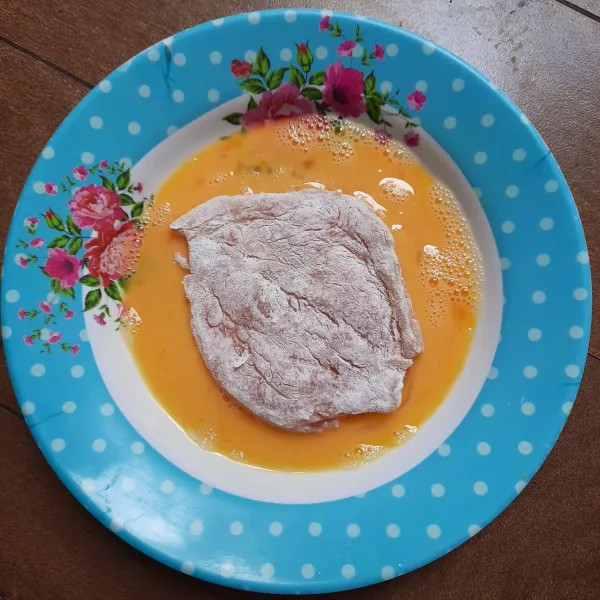 Celupkan dada ayam ke dalam kocokan telur hingga semua permukaannya terbalut telur.