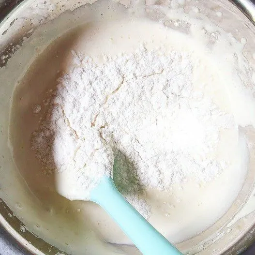 Ayak tepung terigu bersama baking powder, kemudian masukan secara bergantian dengan susu dan mentega cair. Aduk menggunakan spatula.