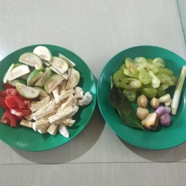 Iris tempe bentuk korek api, iris terong bulat (1 terong jadi 8 bagian kecil). Iris tomat kecil memanjang, iris serong belimbing wuluh. Sisihkan.