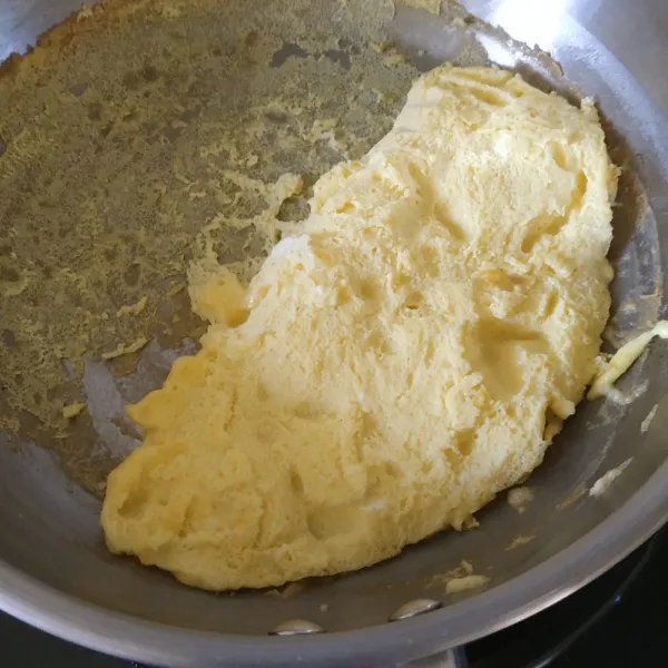 Lelehkan mentega. Tuang adonan omelette ke panci. Masak sambil diaduk agar teksturnya tetap lembut. Kumpulkan telur di bagian pinggir panci. Balik jika sudah matang.