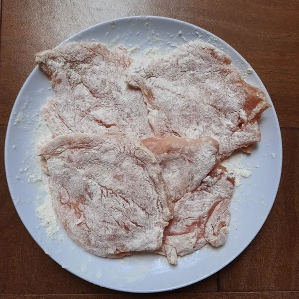 Lumuri seluruh permukaan ayam dengan tepung terigu.