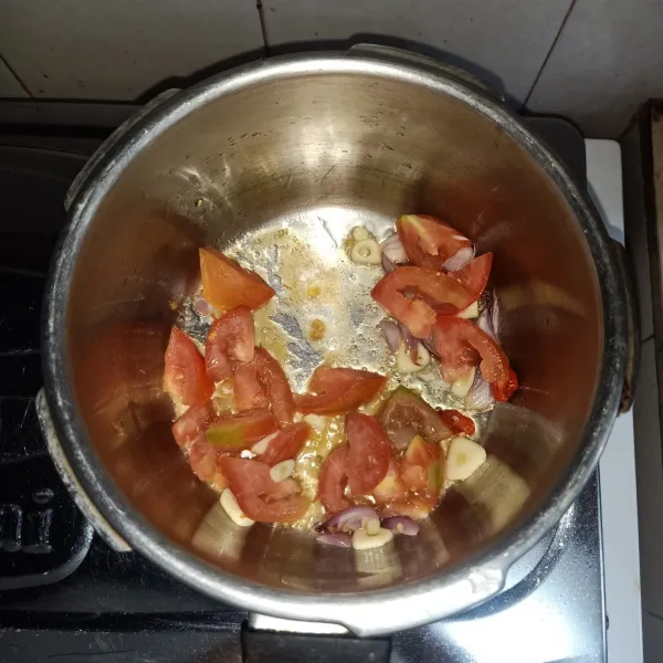 Panaskan minyak dalam wajan. Tumis tomat, bawang putih, bawang merah, dan cabe merah hingga harum.