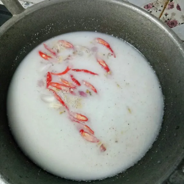 Siapkan kuali, lalu campur santan dan bumbu iris. Masak hingga mendidih.