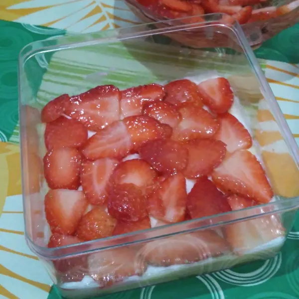 Beri potongan buah strawberry.